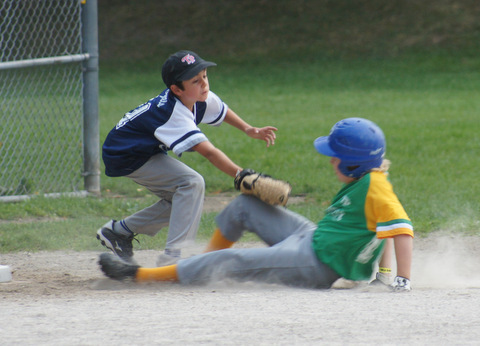 Royals pitcher Lewis (11) applies the tag on a sliding Owen (10) to complete a nifty 7-8-1 putout in the third inning.