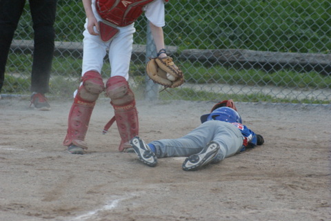 With style and flair, Ethan (36) slides under the tag attempt of Cardinals catcher Jaden (44) in the bottom of the third to give TP a 8-3 advantage.